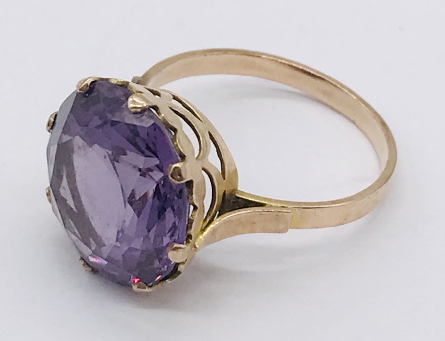 An 18ct gold ring set with large central amethyst