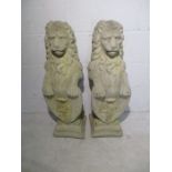 A pair of concrete lions modelled rampant, holding armorial shields - approx. height 80cm