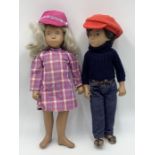 Two Sasha dolls, one blonde girl with plaid dress and matching hat along with a brunette boy with