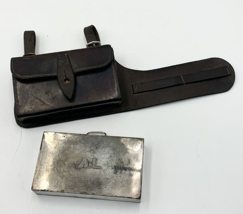 A war era leather pouch with fitted metal box designed to attach to a belt. Marked for The Army &