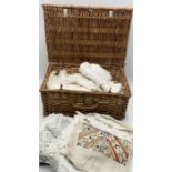 A wicker hamper of vintage table linen