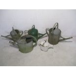 A collection of five vintage galvanised watering cans