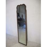 A vintage mahogany full length mirror with shaped top.