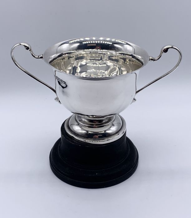 A hallmarked silver two handled trophy on wooden base, silver weight 161.5g