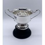 A hallmarked silver two handled trophy on wooden base, silver weight 161.5g