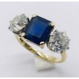 A diamond and sapphire three stone ring. The diamonds measuring 1ct each (6.5mm diameter x 3.75mm