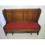 A traditional style settle with upholstered seat
