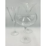 A set of three oversized cocktail glasses overall height approximately 50cm