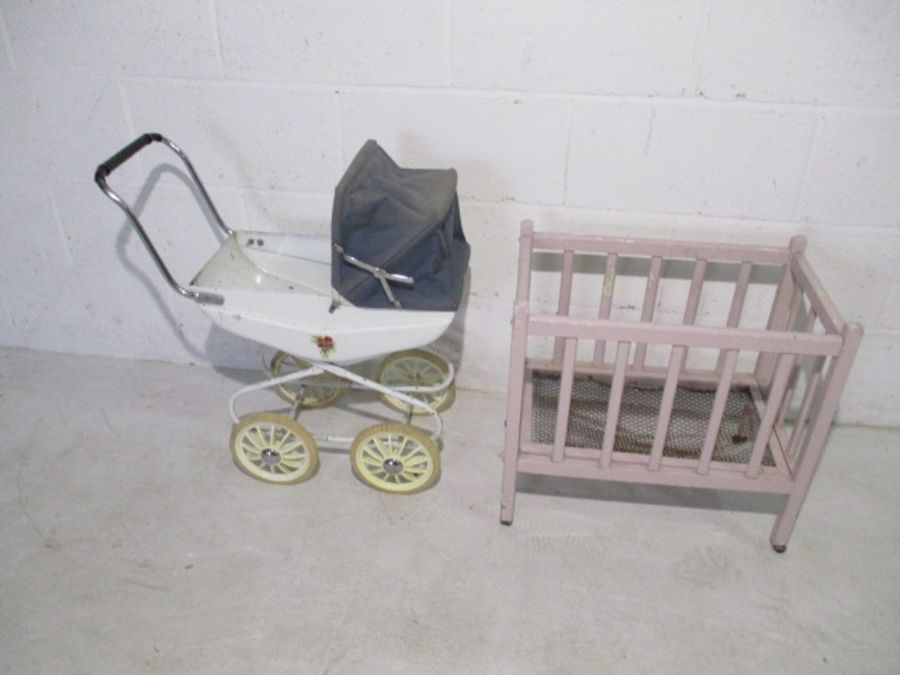 A vintage child's pram and wooden framed cot