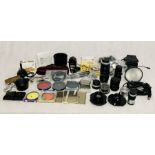 A collection of various photographic equipment and lenses including a Quantum Turbo Flash, a