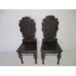 A pair of ornate carved Victorian hall chairs