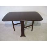 A modern, dark wood, drop leaf table.