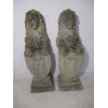 A pair of reconstituted stone Lions Rampant, holding armorial shields. Height approx. 83cm