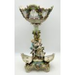 A Dresden style porcelain centrepiece with scrolling base and encrusted floral decoration with two