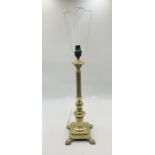 A brass column table lamp on claw feet.