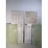 Two painted Edwardian four panelled doors along with a painted pair of cupboard doors