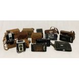 A collection of various vintage cameras including Kodak Brownie Reflex, Soho Cadet, Zeiss Ikon
