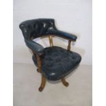 An Edwardian office chair with faded blue leather button back seat and back rest
