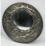 A pewter wall mirror with embossed Oriental style dragon design with hardstone eye