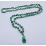 An apple jade necklace with pierced and carved pendant