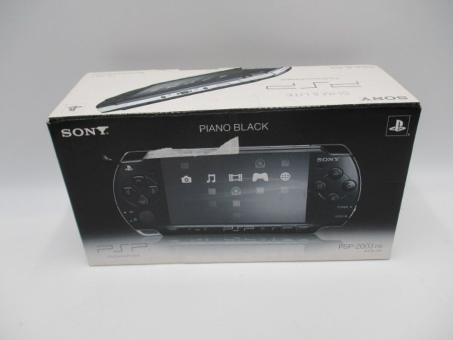 A boxed Sony PSP-2003 Piano Black handheld console with charger, along with four PSP games ( - Image 2 of 10