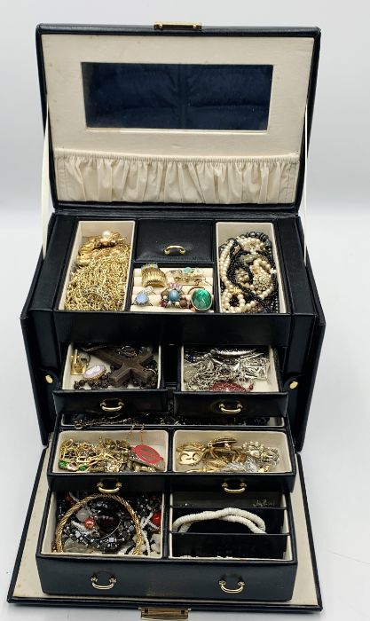 A collection of costume jewellery in carry case including a number of rings, brooches, beads etc.