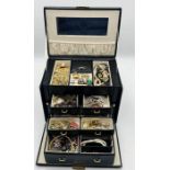 A collection of costume jewellery in carry case including a number of rings, brooches, beads etc.