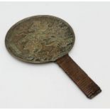 A Chinese hand held mirror with dragon pattern and character marks to back