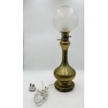 A vintage brass oil lamp with etched detail to base and round glass shade