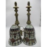 A pair of ecclesiastical style lamps with Tiffany type shades.