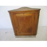 An antique, elm hanging corner cupboard.