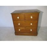 A Victorian, pine chest of four drawers with ceramic handles.