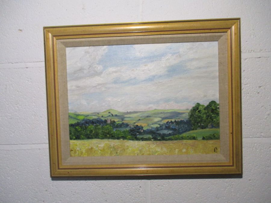 A framed oil painting of a countryside scene - overall size 39cm x 49cm
