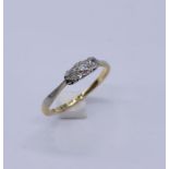 An 18ct gold and platinum illusion set diamond three stone ring