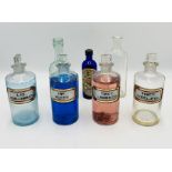 A collection of vintage bottles including four chemists bottles