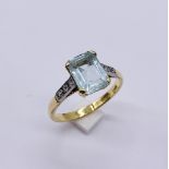 An emerald cut aquamarine ring of approx. 2.5ct with three small diamonds on each shoulder set in