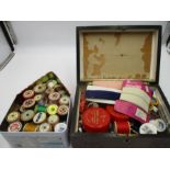 An assortment of vintage cotton reels and sewing accessories. In one wooden box and one tin.
