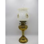 A vintage brass oil lamp with embossed glass shade