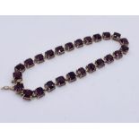 A 9ct gold tennis bracelet set with garnets