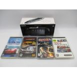 A boxed Sony PSP-2003 Piano Black handheld console with charger, along with four PSP games (