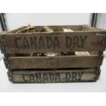 A collection of miscellaneous items in a vintage Canada Dry advertising crate, including a miners