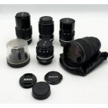 A collection of Nikon camera lenses including Tokina 28-70mm AT-X Pro in soft pouch, Nikkor 35-105mm