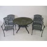 A metal circular garden table with four matching chairs