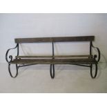 A slatted garden bench with wrought iron supports