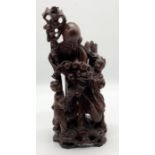 An Oriental carved hardwood figure of a Deity