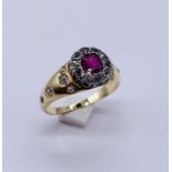 An unmarked (probably 18ct gold) diamond and ruby ring set with diamonds to the shoulders