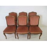 A set of six French upholstered dining chairs with carved decoration on cabriole legs