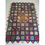 A richly coloured patchwork style wall hanging/bed spread