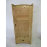 A pine wardrobe with one drawer under