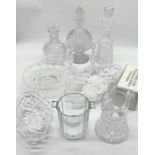 A collection of various cut glass including a Waterford crystal decanter, moon flask decanter, etc.